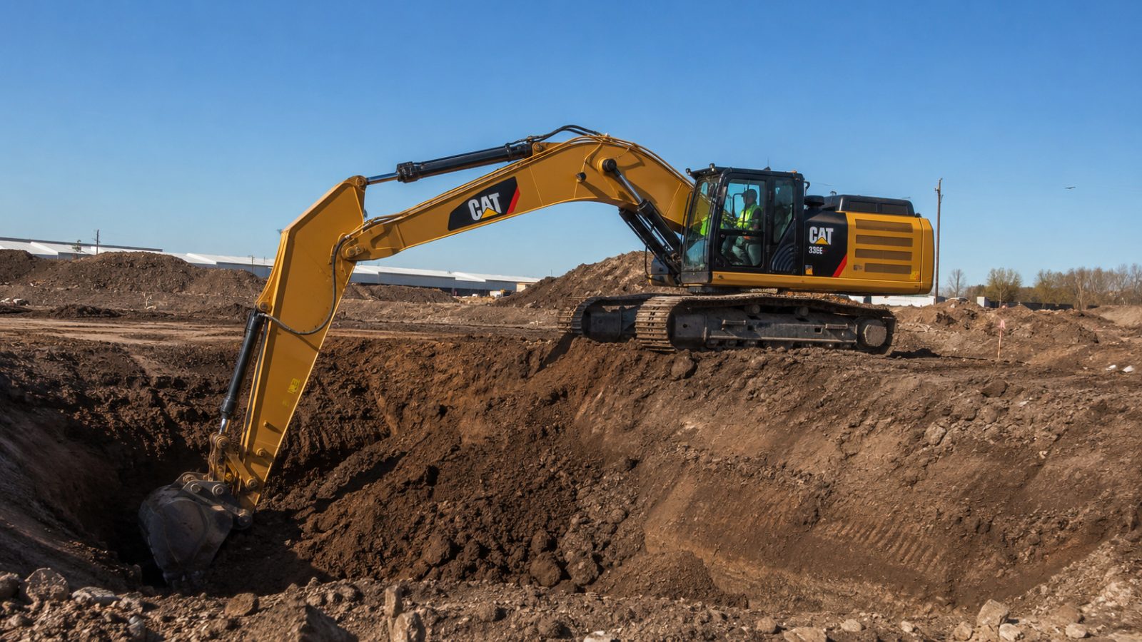 Excavator CAT pe șenile săpând pe șantier